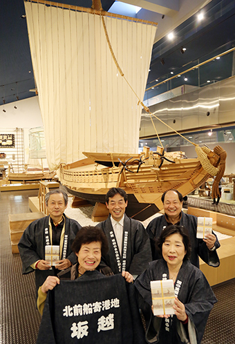 「北前船寄港地」をテーマに地域おこしを始めた「坂越のまち並みを創る会」のみなさん。後ろは赤穂市立歴史博物館の廻船模型