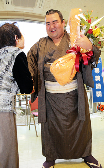 笑顔で花束を受け取った琴奨菊関