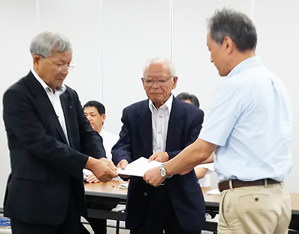 県知事宛ての要望書を県民局へ提出する木村音彦会長=中央=と有田光一参与(左)