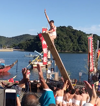 「バタ架け」で板に上り、観客の歓声に応えるボールドウィンさん