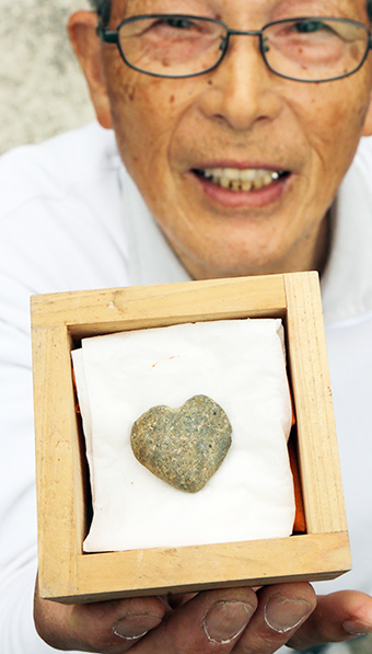 珍しい形の「ハート石」を見つけた福元祥藏さん