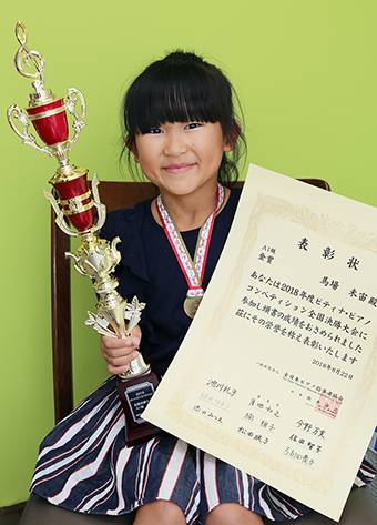 ピティナ・ピアノコンペティションの金賞トロフィーを手に笑顔の馬場未宙さん