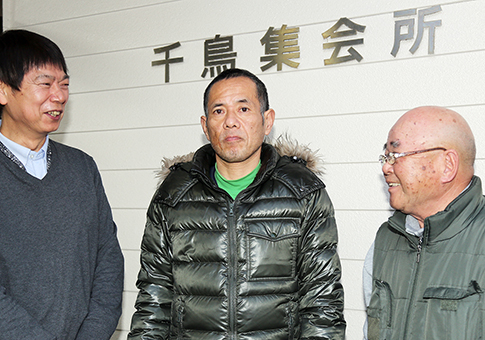 善意の見守りで高齢者を救い、自治会関係者から称えられる藤本敏也さん=中央