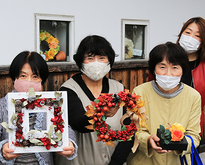 秋をテーマにしたフラワーアレンジメント作品を展示している「花工房フラワー教室」のみなさん