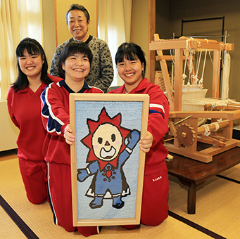 完成した新作を手に笑顔の赤穂緞通同好会のみなさん