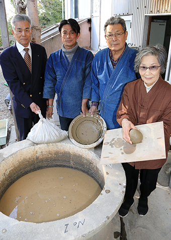 大嶋黄谷子孫の靖彦さん(左)から提供された陶土で雲火焼の完全再現を目指す桃井香子さん(右)ら