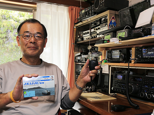 太平洋横断中の堀江謙一さんと無線交信した井口勝則さん。手に持っているのは前回交信時に送られたＱＳＬカード
