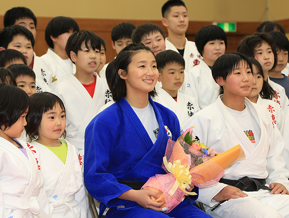 赤穂柔道スポーツ少年団の子どもたちと記念写真に収まる金知秀さん＝前列中央。右は妹の智賢さん