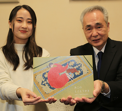 赤穂緞通の魅力を伝える絵本『あこのとくとうせき』を寄贈した廣津真由さん(左)