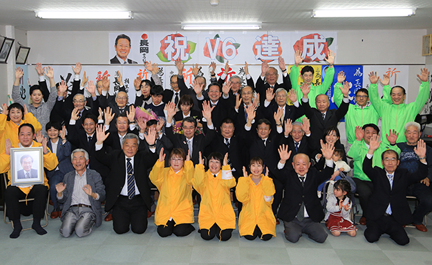 無投票で６選を果たし、支援者と万歳三唱する長岡壮壽氏＝後列中央あたり