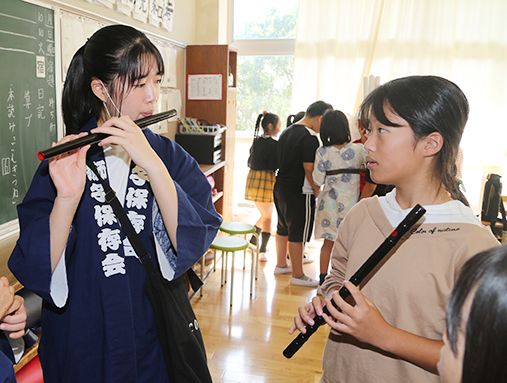 保存会メンバーから横笛の吹き方を教わる児童