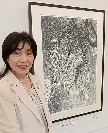 春陽展版画部で最優秀賞を受賞した尾崎明美さんと受賞作『春孕む』